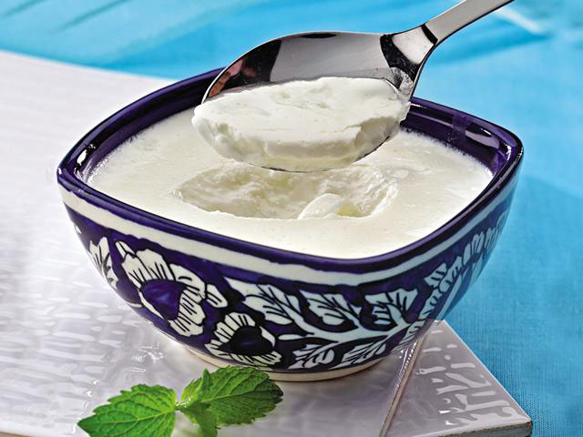 A bowl of curd from which a spoon has been removed